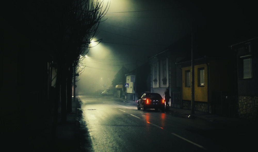 Mujer por una calle solitaria y oscura