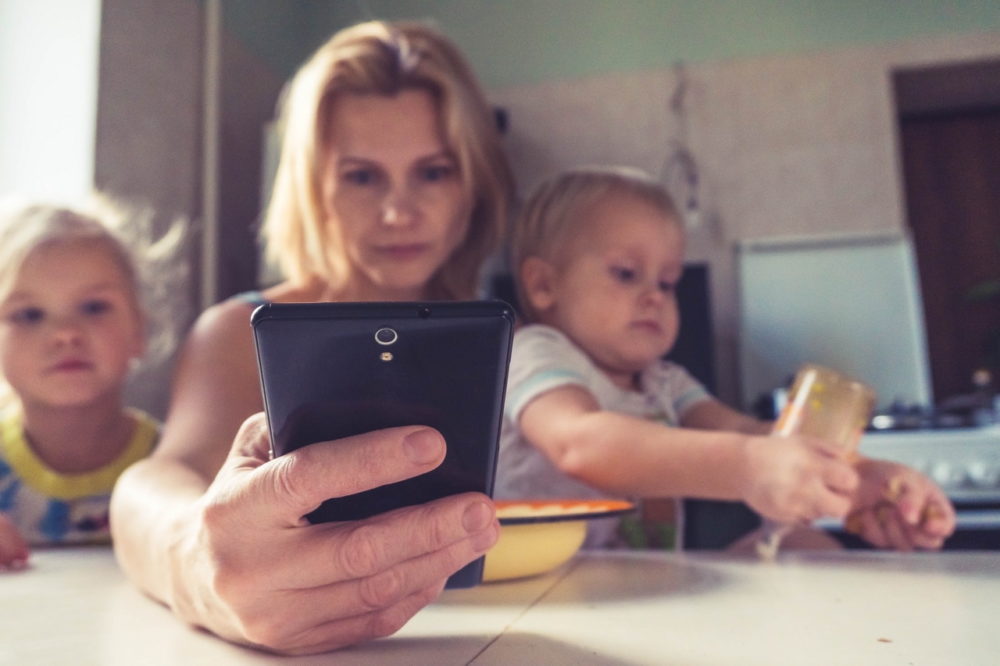 madre con niños utilizando un smartphone