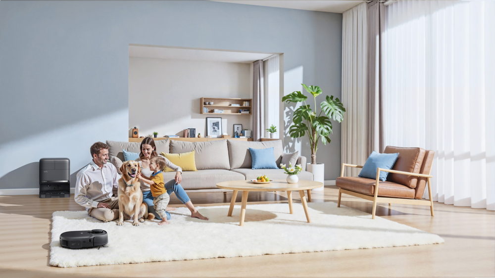 eufy C28 Omni llega a España: 15.000 Pa, DuoSpiral y estación todo en uno por 499,99 € Familia con perro en sala moderna, alfombra blanca y robot aspiradora en funcionamiento.