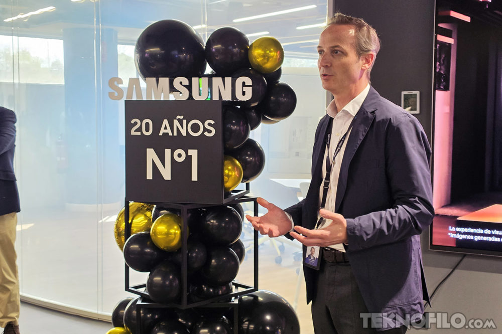 Nadie puede con Samsung: 20 años liderando el mercado global de TVs Hombre en evento celebrando 20 años de Samsung como líder, con globos decorativos negros y dorados.