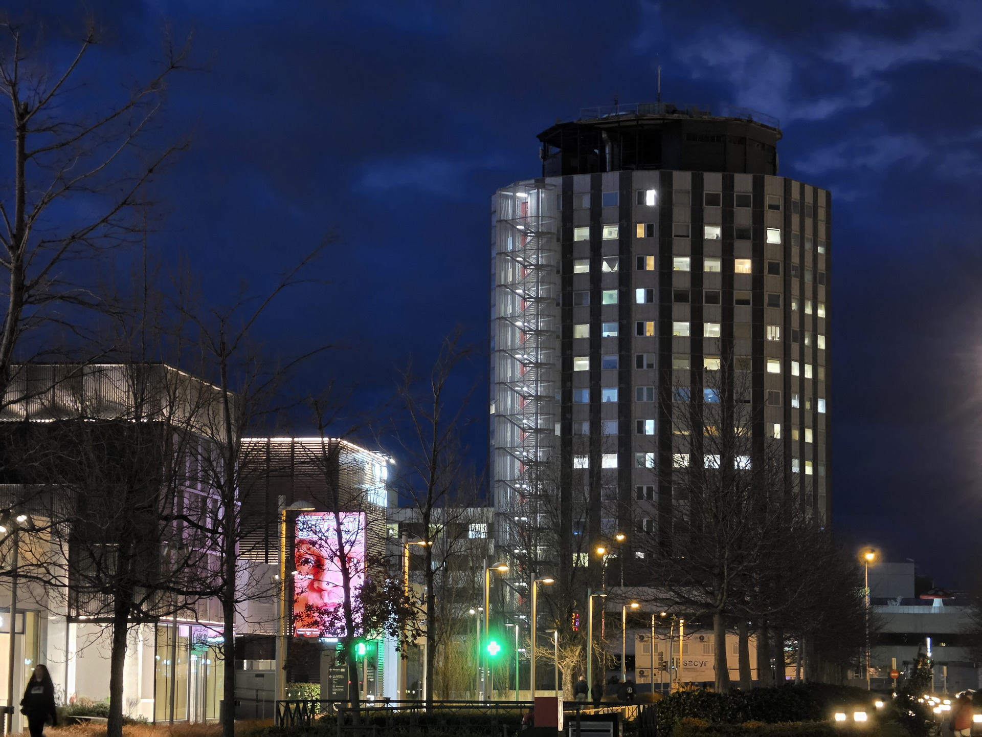 Edificio iluminado por la noche con cielo azul oscuro y luces brillantes en la ciudad.