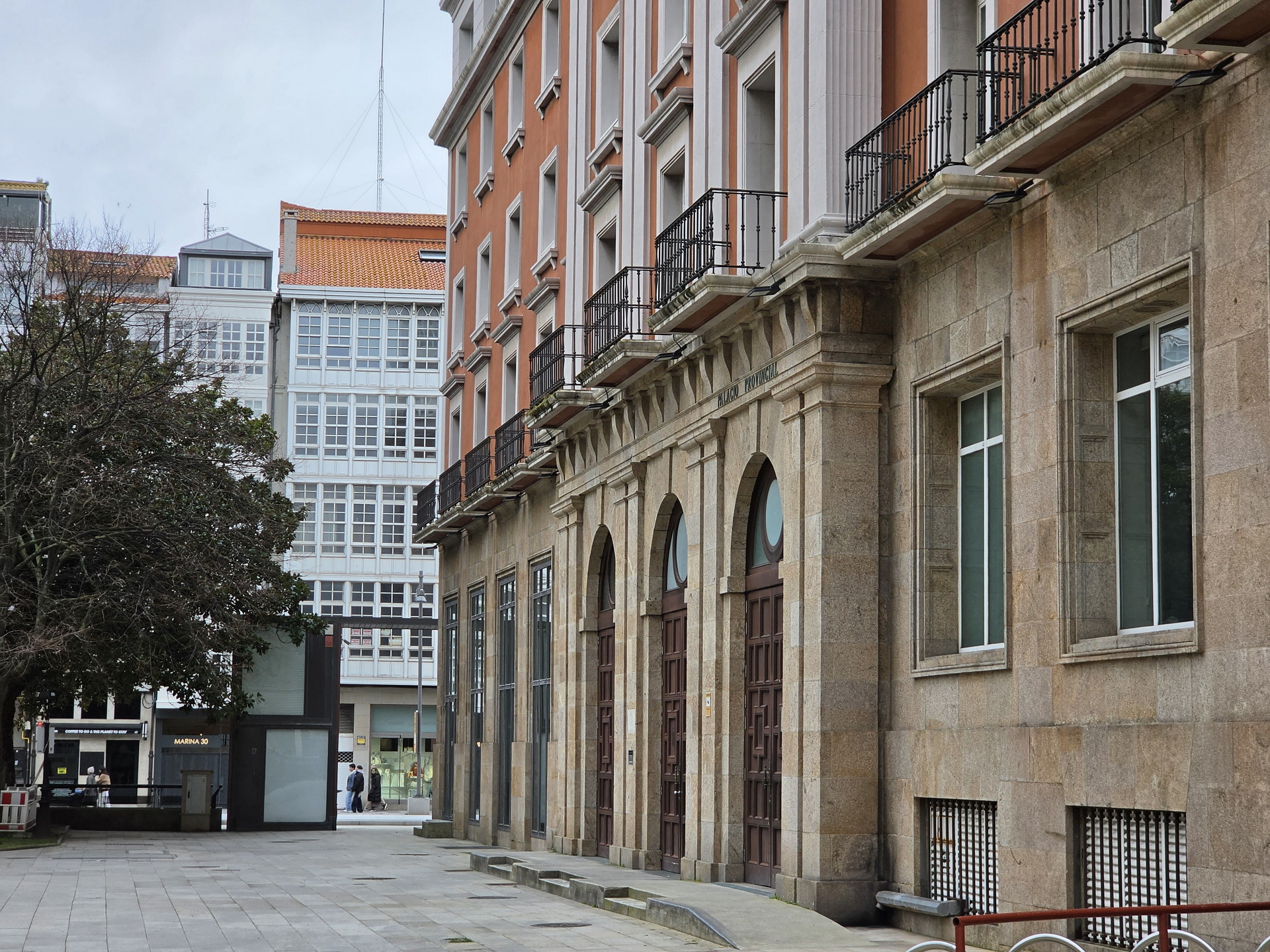 Edificio histórico con ventanas arqueadas en una calle peatonal de una ciudad española.