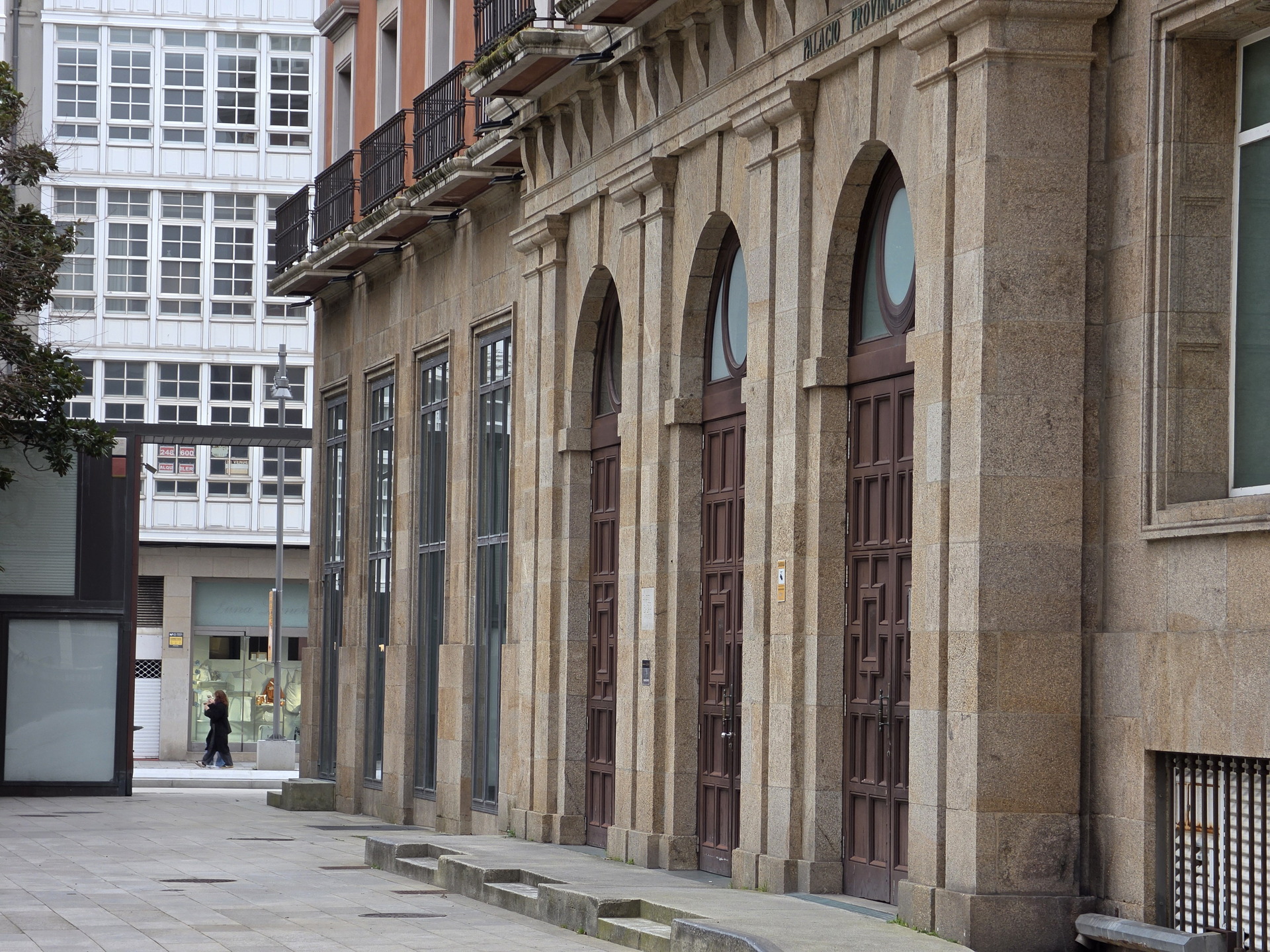 Fachada histórica de edificio en la ciudad, con puertas de madera y arquitectura clásica.