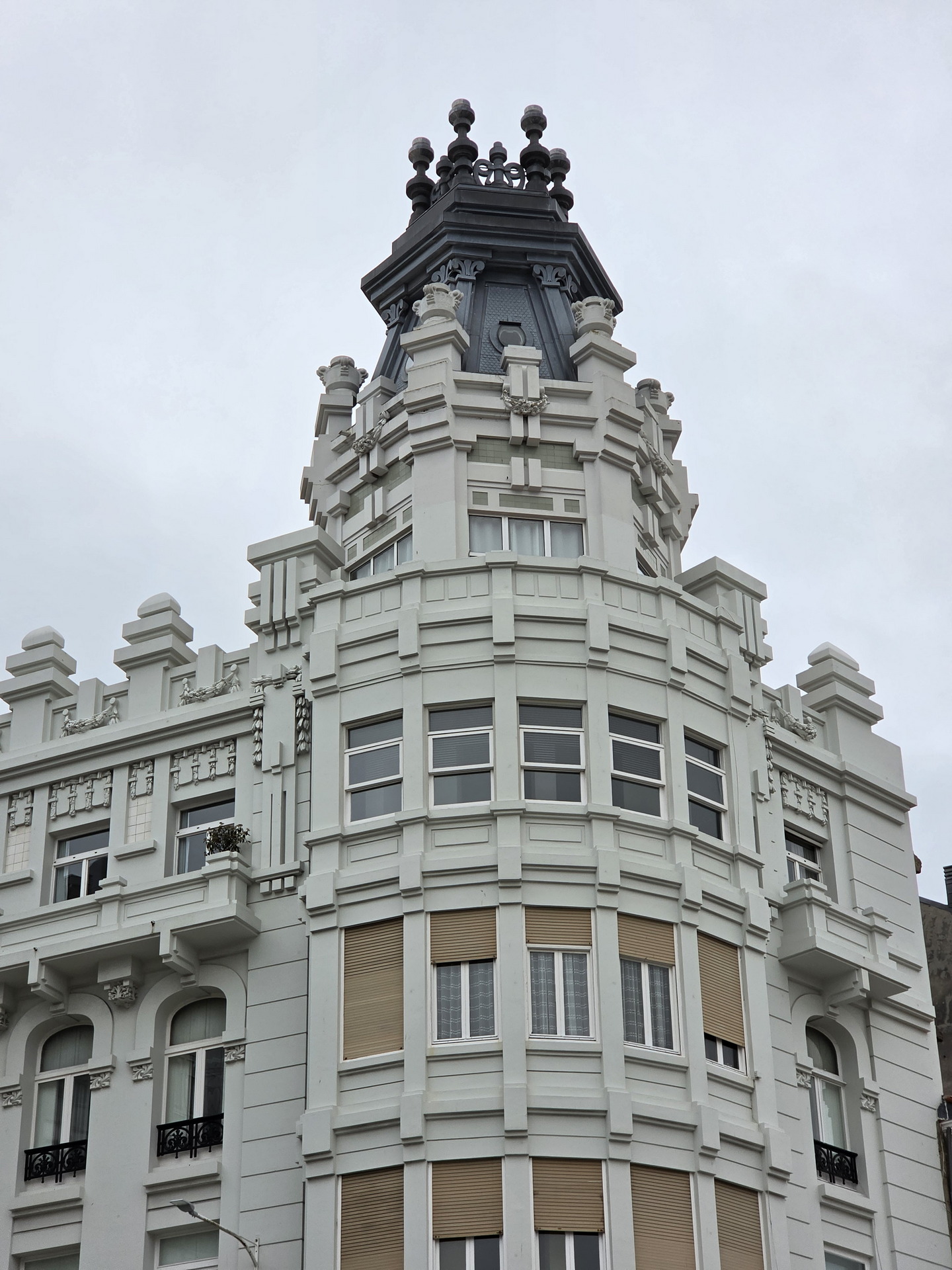 Edificio histórico con torreón arquitectónico en una ciudad, cielo nublado. Elegancia y detalle en diseño urbano.