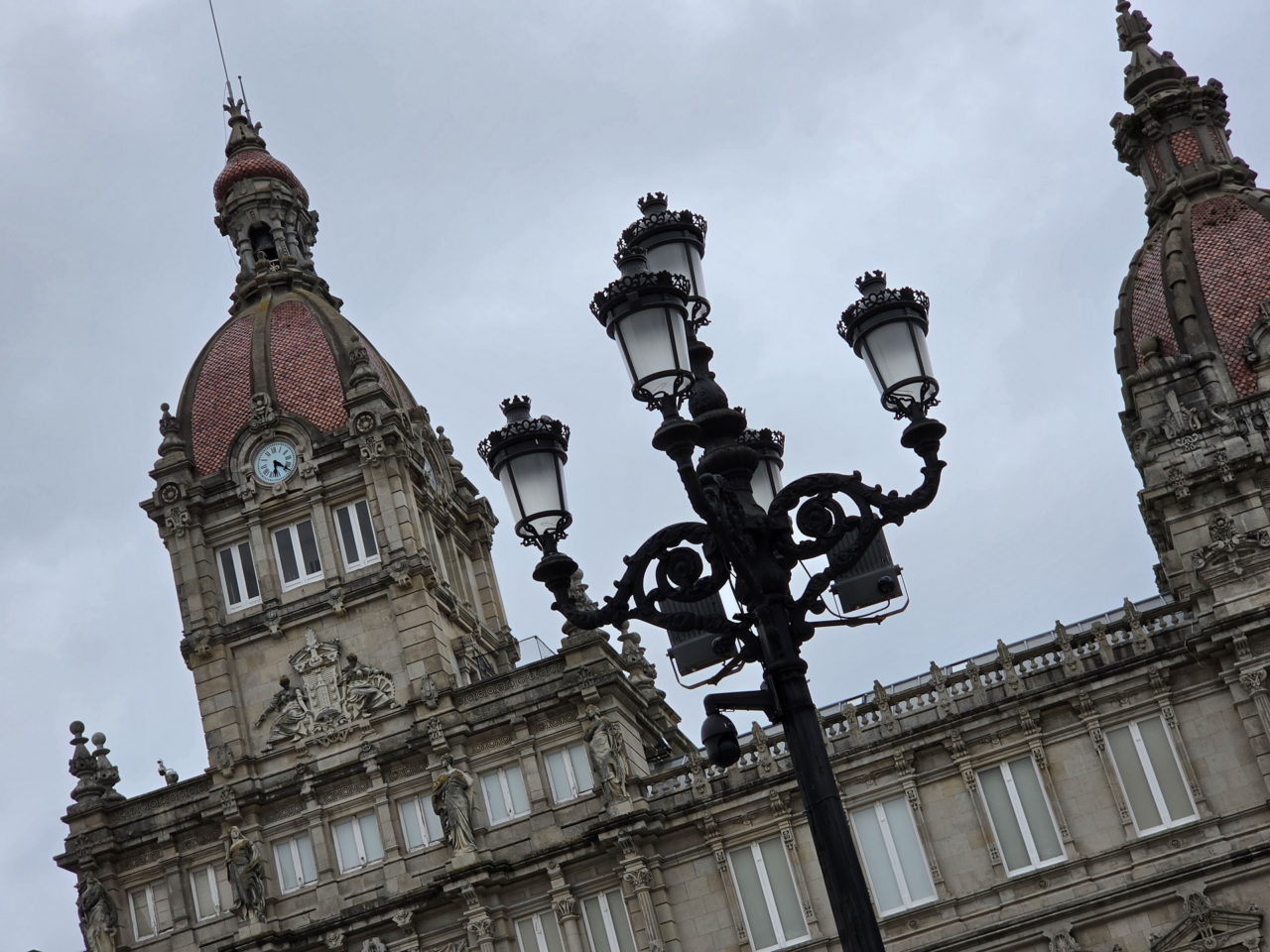 Edificio histórico con detalles arquitectónicos y farola ornamental en día nublado.