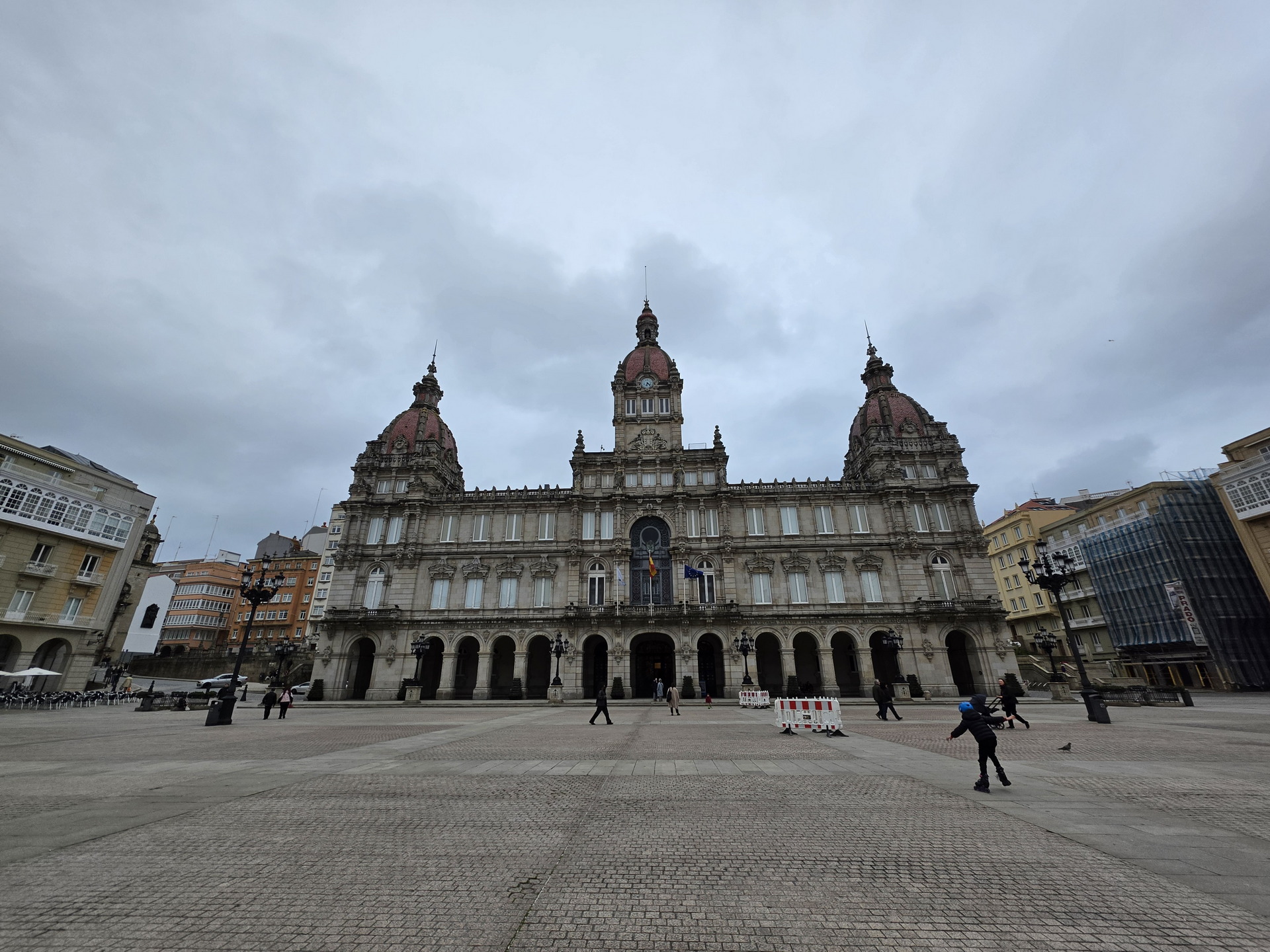 Edificio histórico en plaza principal de A Coruña bajo un cielo nublado. Ambiente urbano y arquitectura clásica.