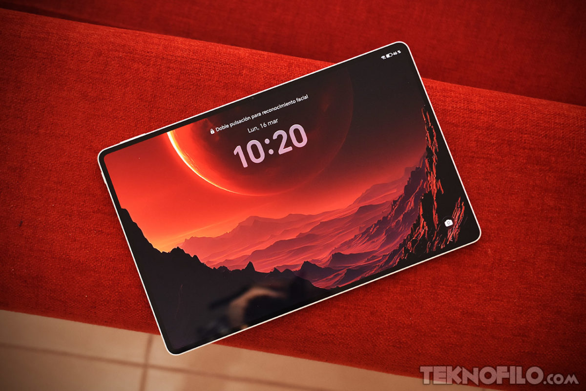 Análisis y opinión de la tablet HONOR MagicPad 4 Tablet con fondo de pantalla de paisaje planetario en tonos rojos, mostrando la hora 10:20 sobre un sofá rojo.