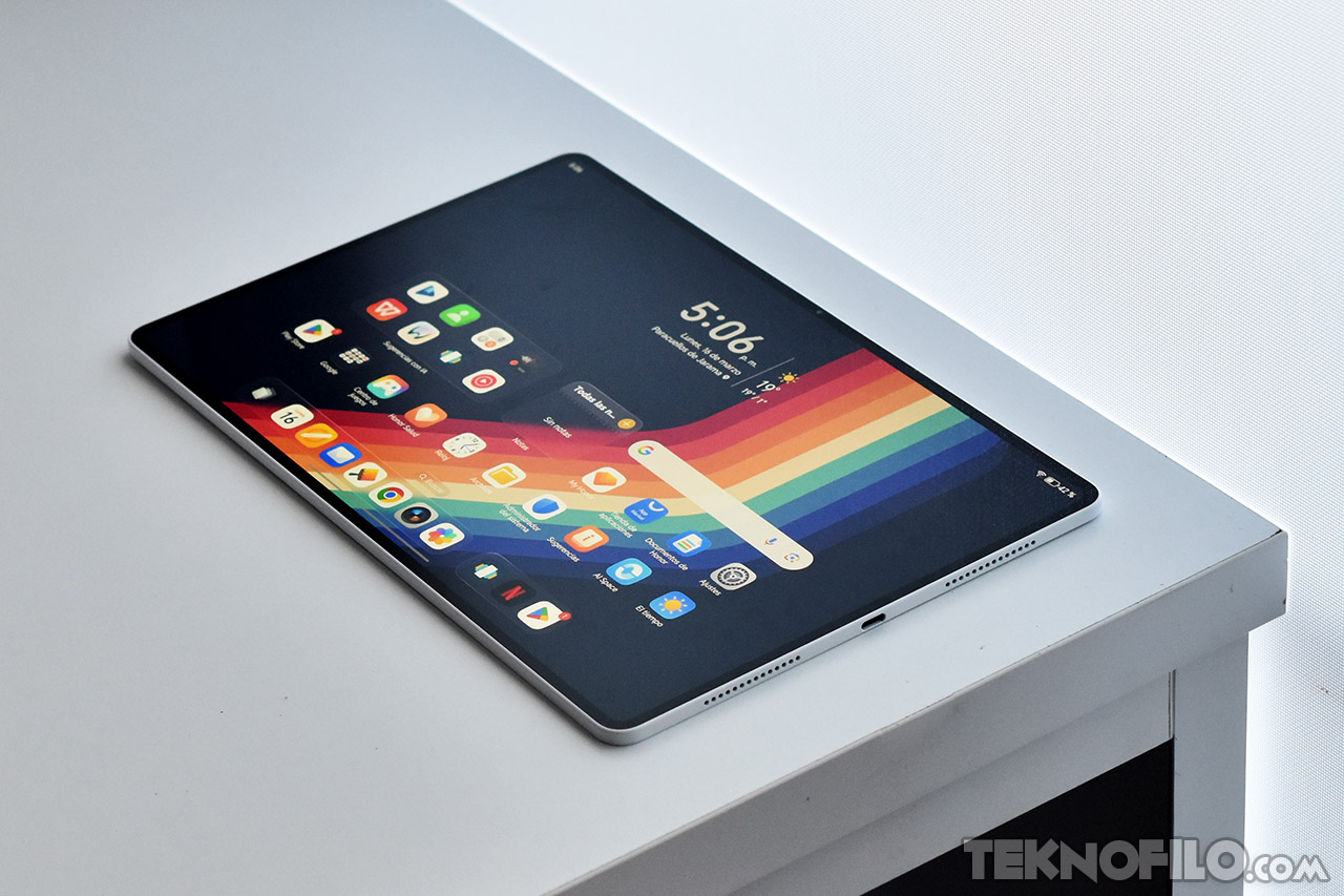 Tableta moderna sobre escritorio con pantalla colorida y múltiples aplicaciones visibles en la interfaz.