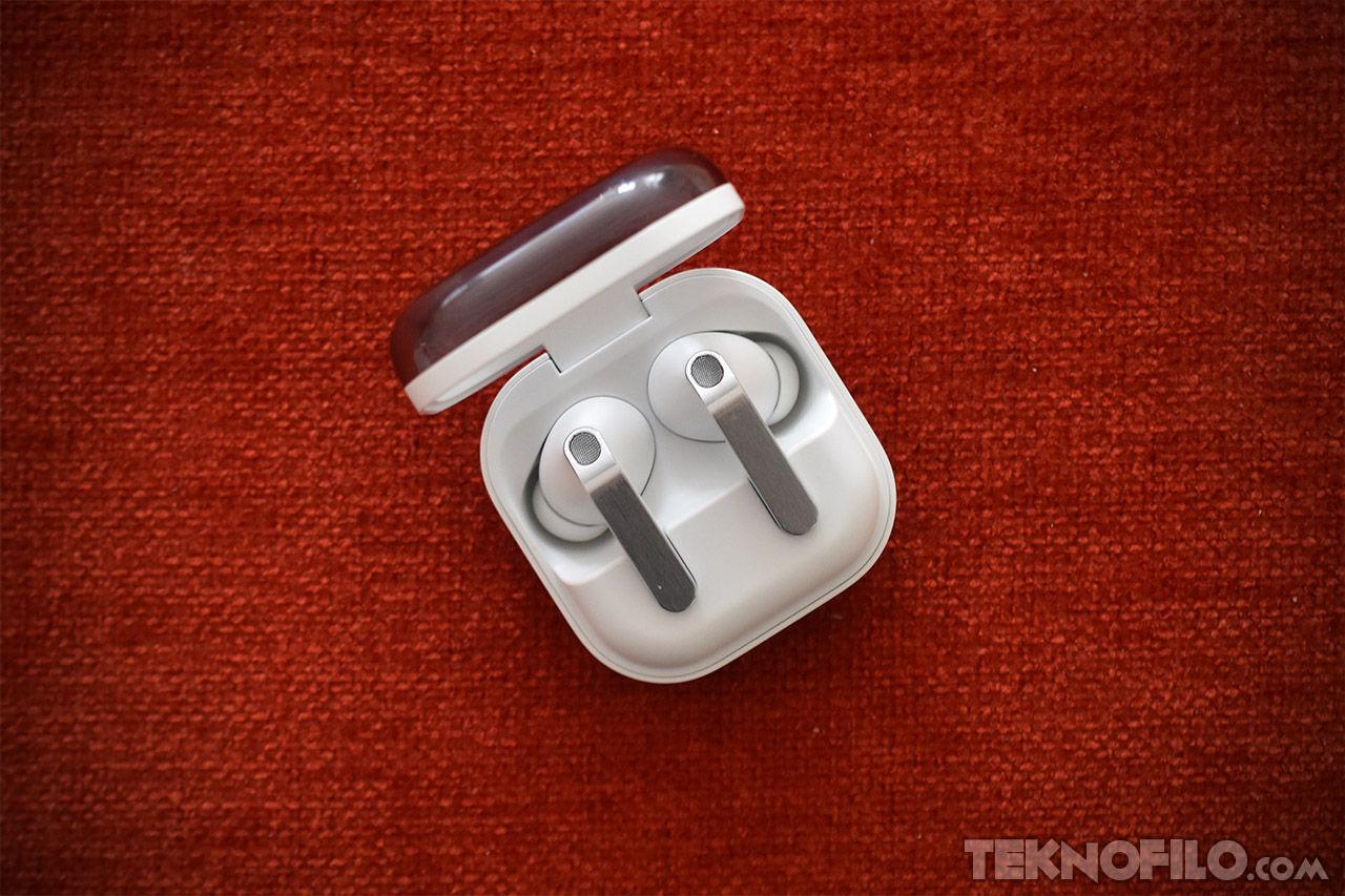 Auriculares inalámbricos en estuche sobre fondo rojo intenso. Diseño moderno y elegante para alta calidad de sonido.