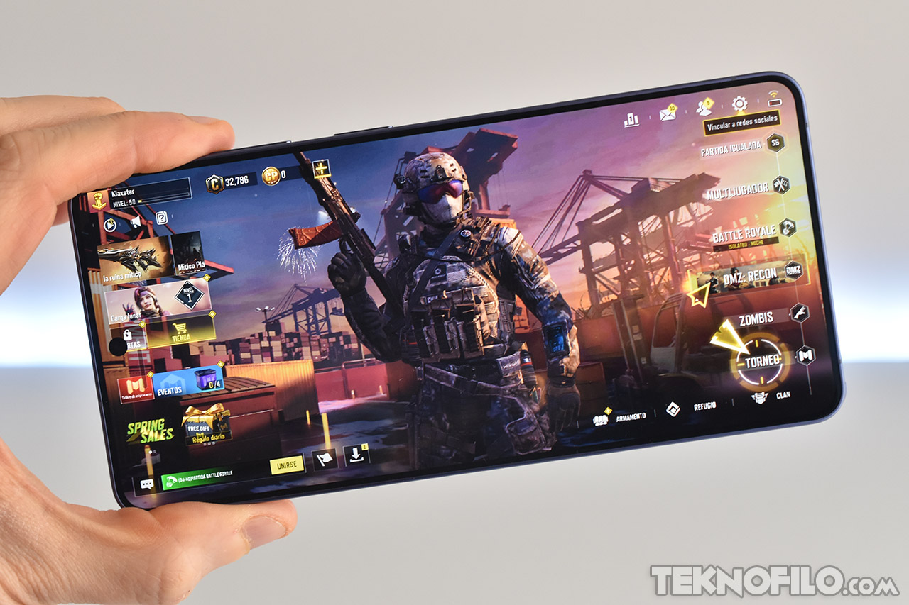 Juego de disparos mobile en smartphone mostrando un personaje militar en pantalla con interfaz de usuario.