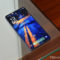Samsung podría usar pantallas BOE en el Galaxy S27 para reducir costes Smartphone sobre mesa de vidrio con pantalla encendida, mostrando un fondo artístico en tonos azul y naranja.