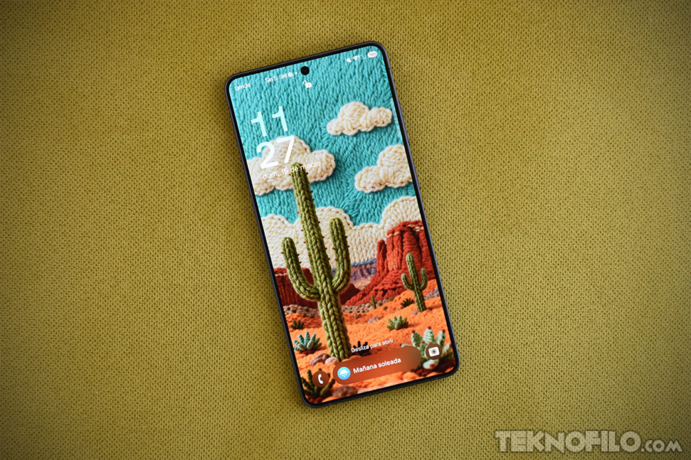 Samsung lo consigue: Podrás enviar archivos por AirDrop a un iPhone desde un Galaxy Teléfono inteligente sobre tela amarilla mostrando fondo de pantalla de paisaje desértico con cactus.