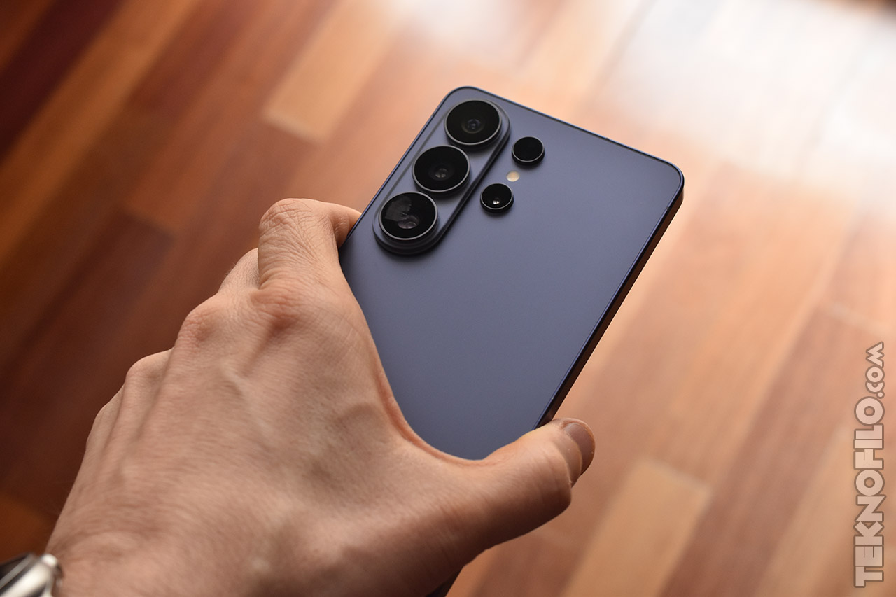 Teléfono inteligente moderno con cámara avanzada en mano sobre fondo de madera.