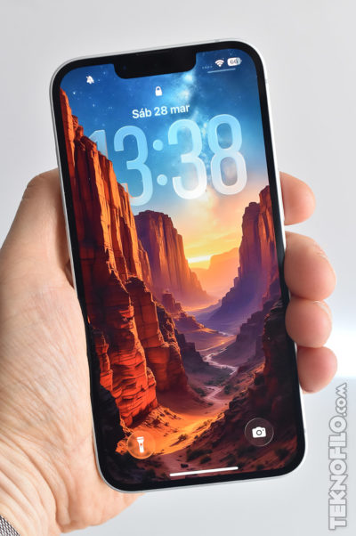 Pantalla de móvil mostrando un cañón al amanecer como fondo de pantalla, con hora 13:38 y fecha sábado 28 de marzo.