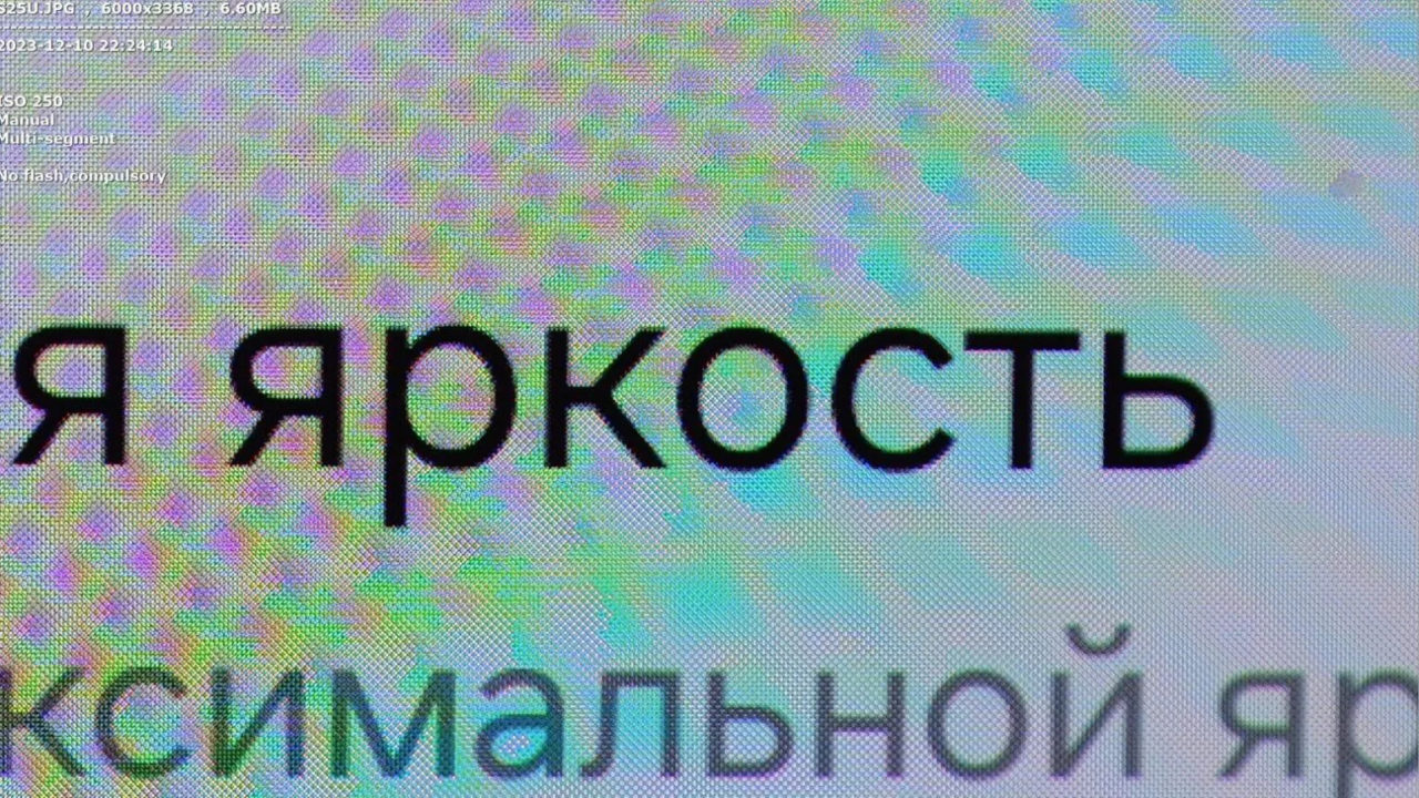 Texto en ruso sobre fondo colorido de píxeles aumentados en una pantalla de monitor.