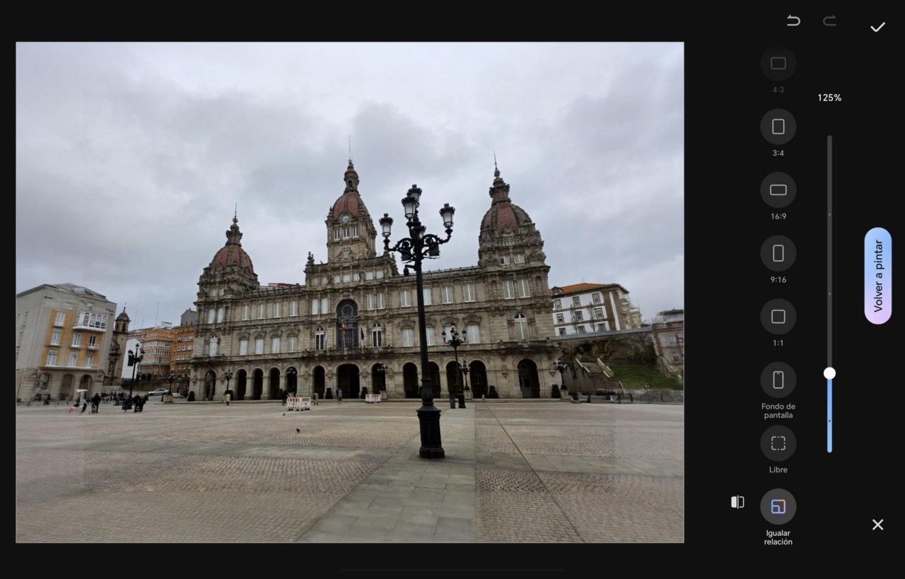 Edificio histórico en una plaza de A Coruña, España, con cielo nublado y farolas al frente.