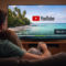 Ver YouTube en la TV será más molesto: llegan anuncios de 30 segundos imposibles de saltar Pareja viendo video en YouTube en TV, paisaje de playa tropical; opción de omitir anuncio visible.