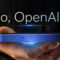 Mano sosteniendo un teléfono inteligente de OpenAI con texto Hello, OpenAI phone iluminado en fondo oscuro.