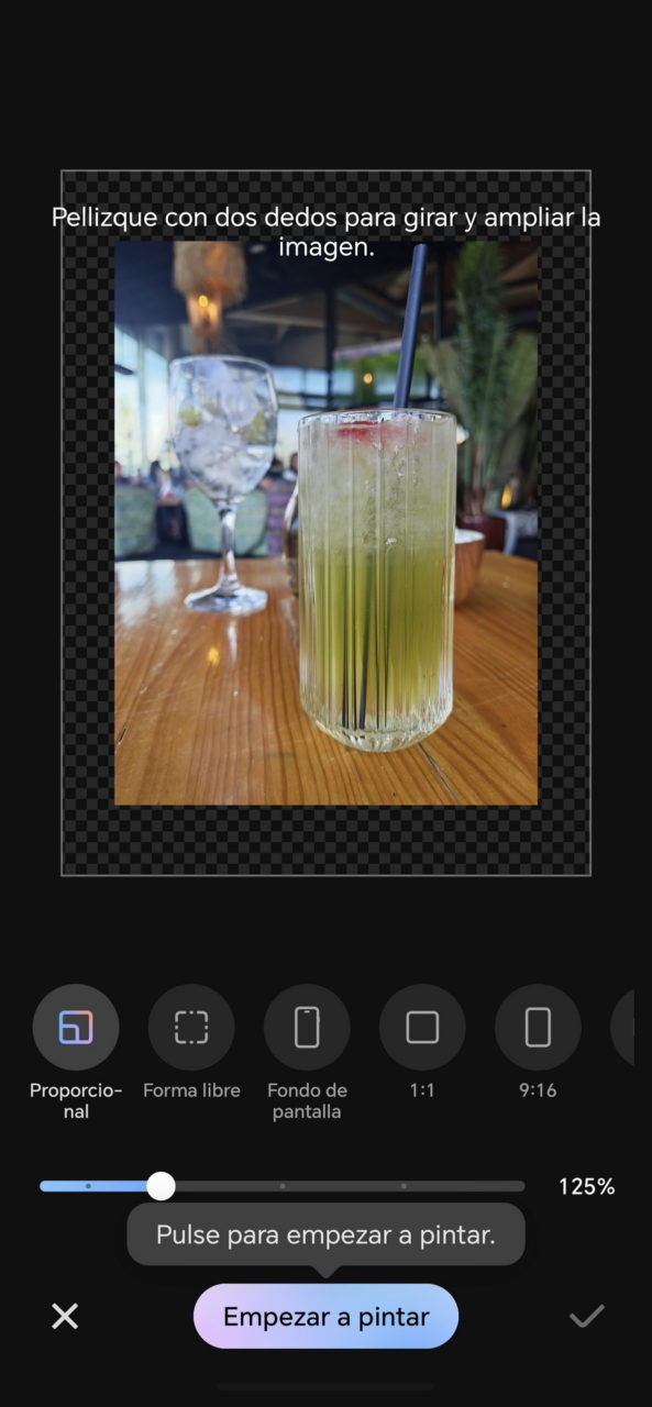 Cóctel verde refrescante en un vaso alto con pajilla, sobre mesa de madera en una cafetería.