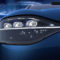 Primer plano de faro delantero de auto eléctrico azul, diseño futurista con fondo de galaxia estrellada.