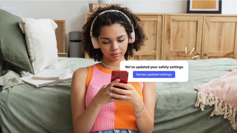 Joven con auriculares en habitación, revisando la configuración de seguridad actualizada en su smartphone.