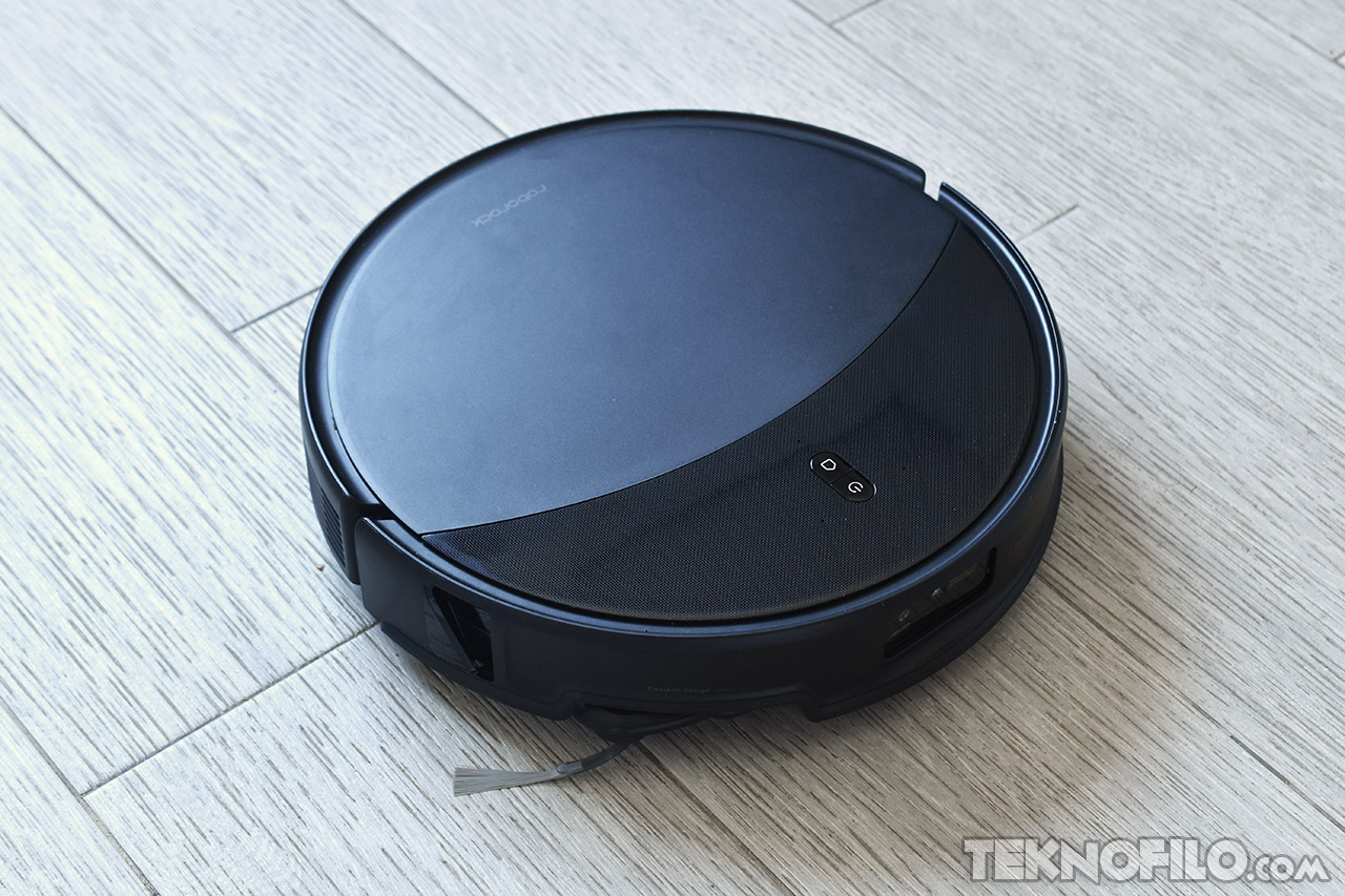 Aspiradora robot en acción sobre suelo de madera clara, tecnología de limpieza automática y eficiente.