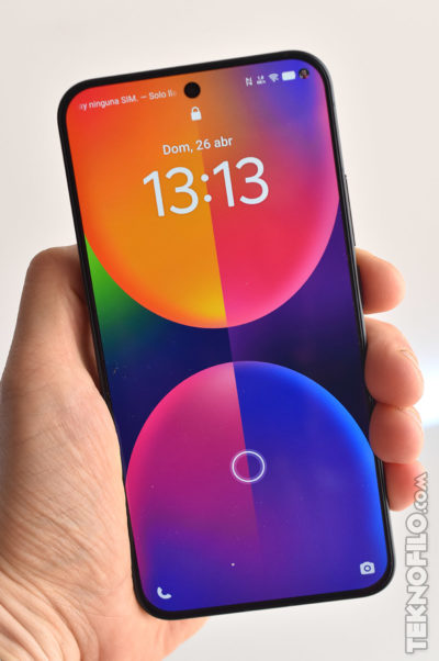 Pantalla de smartphone mostrando hora 13:13 y fecha 26 de abril, diseño colorido y moderno, sin tarjeta SIM.