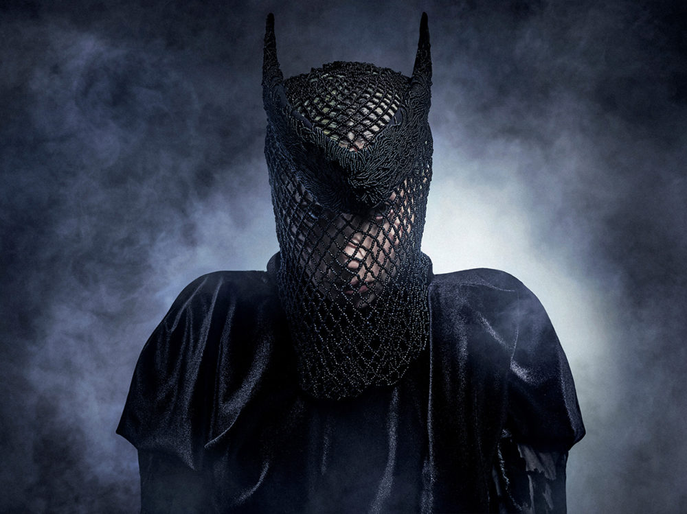 Lady Gaga estrena MAYHEM Requiem en exclusiva en Apple Music el 14 de mayo Persona enmascarada con vestimenta negra y fondo nebuloso, crea una atmósfera de misterio e intriga.