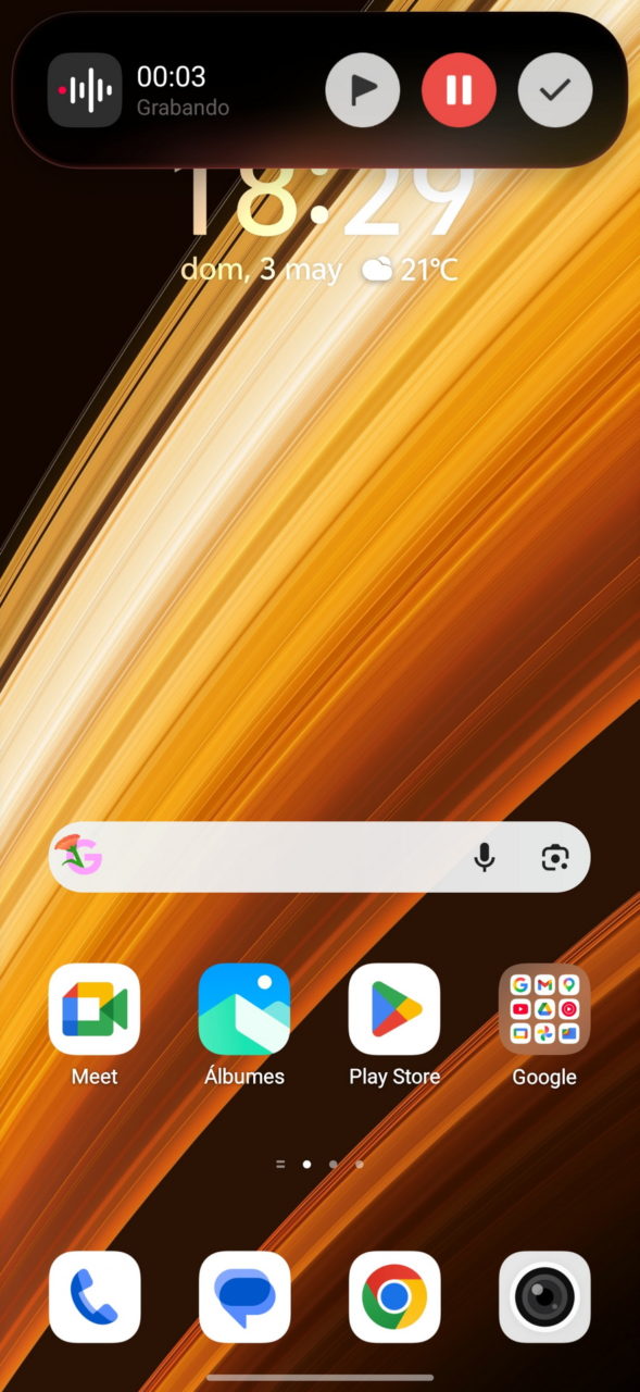 Pantalla de inicio de smartphone con grabadora activa, clima 21°C y varias aplicaciones como Meet y Play Store.