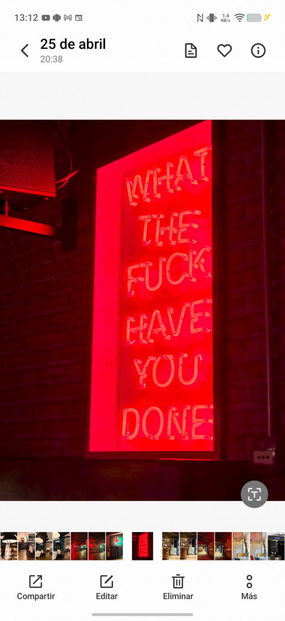 Rótulo de neón rojo con el texto What the fuck have you done en una pared de ladrillo oscuro.