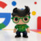 Figura de juguete con gafas verdes y fondo colorido inspirado en Google. Ideal para coleccionistas.