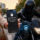 Mujer sorprendida, iPhone bloqueado tras intento de robo por motociclista en ciudad, tecnología de seguridad avanzada.