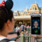 Disneyland ya escanea rostros en sus entradas: así funciona su nuevo sistema de reconocimiento facial Mujer con diadema de orejas en escáner facial de entrada en parque temático. Tecnología de reconocimiento facial.