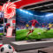 MediaMarkt lanza ofertas especiales en televisores para vivir el Mundial como nunca Televisores en tienda mostrando partido de fútbol en HD, con ambiente de estadio y decoración deportiva.