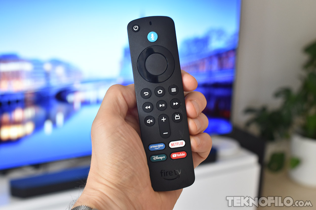 Mando a distancia Fire TV con botones de acceso a Prime Video, Netflix, Disney+ y YouTube frente a televisor.