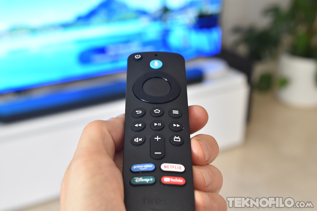 Control remoto de televisión inteligente con botones de acceso rápido a servicios de streaming, sostenido por una mano.