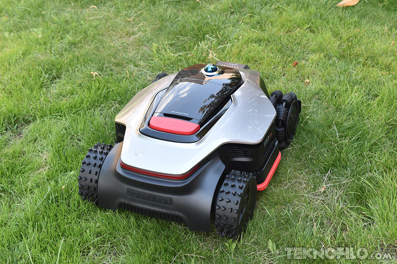Cortacésped robótico sobre césped verde, diseño moderno y eficiente para jardines sostenibles.