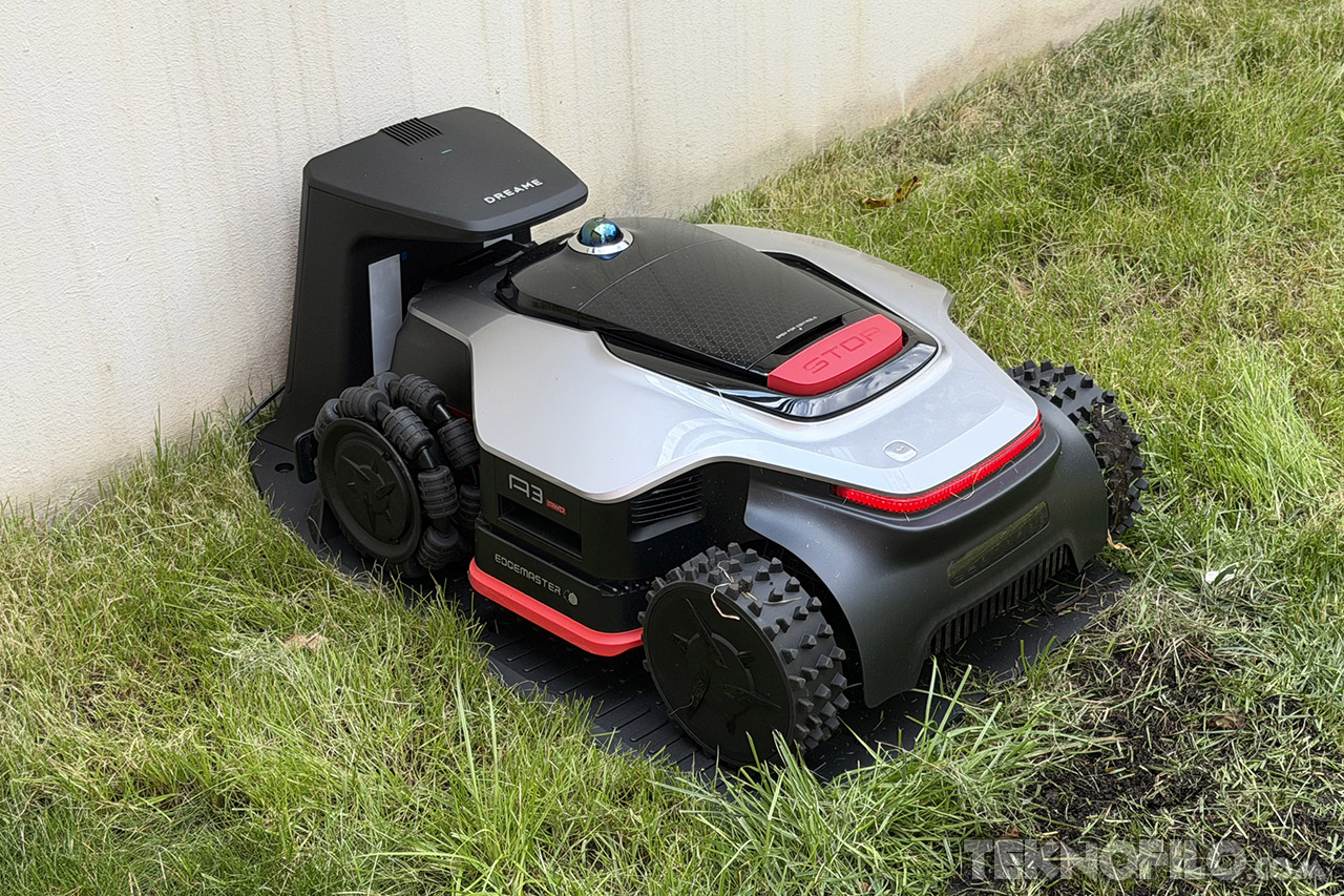 Cortacésped robotizado en césped, modelo avanzado con estación de carga. Tecnología de jardinería automática.