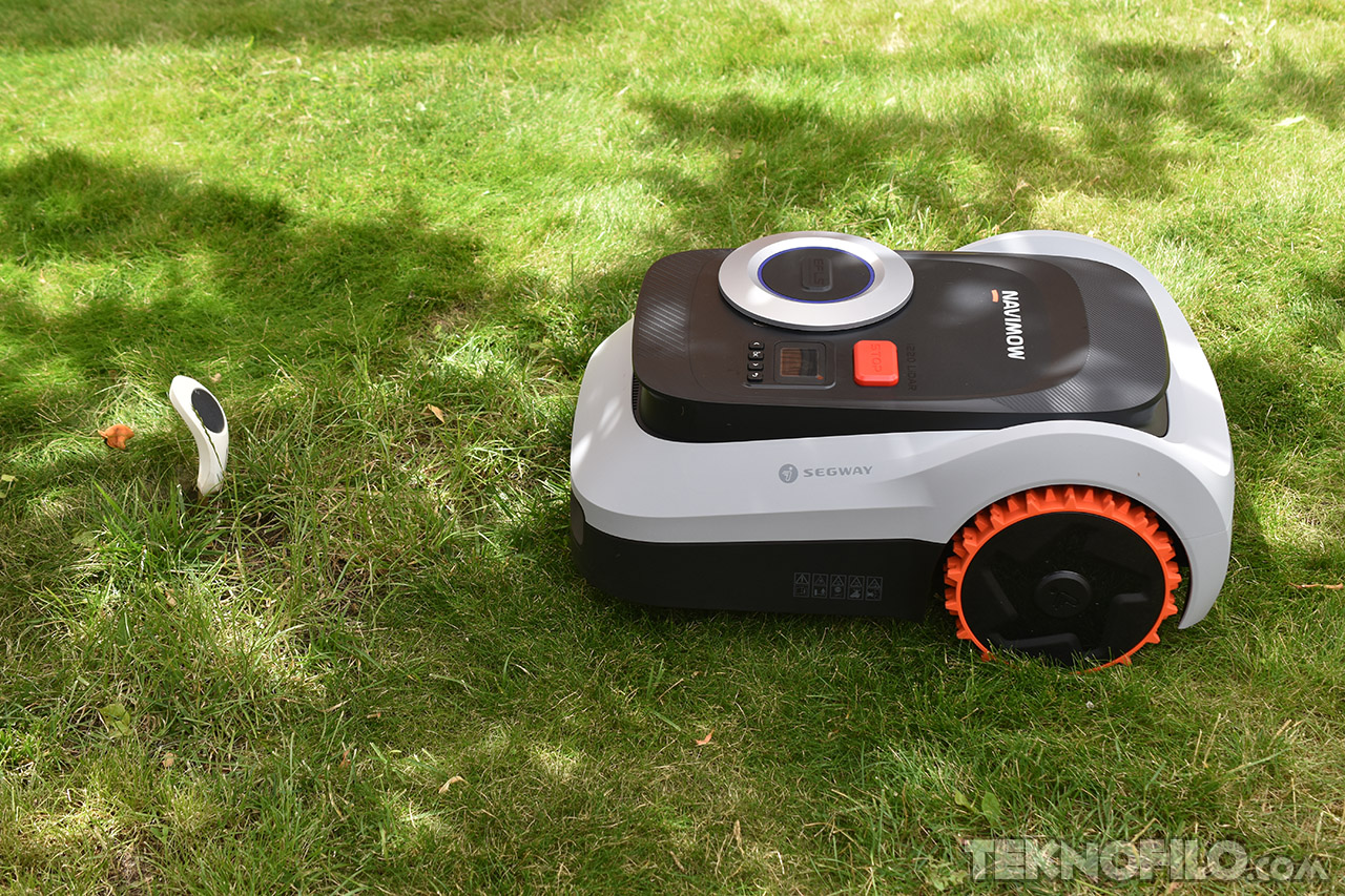 Cortacésped robótico Segway Navimow cortando césped en jardín verde con control de ubicación.