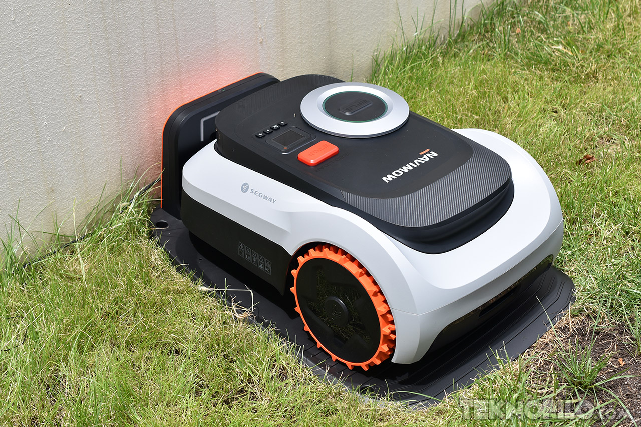 Cortacésped automático Segway en estación de carga sobre césped. Ideal para mantener jardines sin esfuerzo.