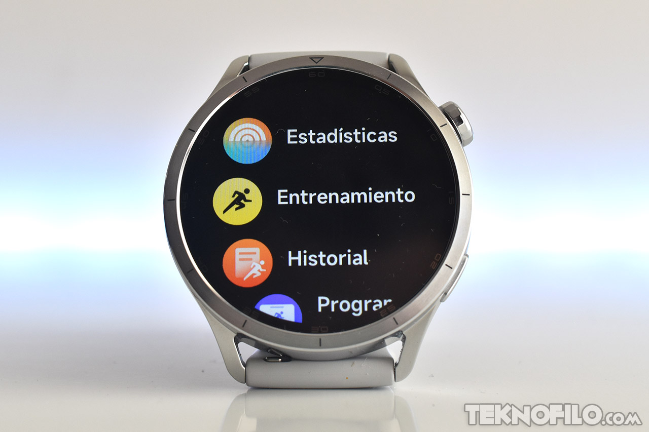 Reloj inteligente con pantalla iluminada mostrando opciones de estadísticas, entrenamiento e historial de actividad.