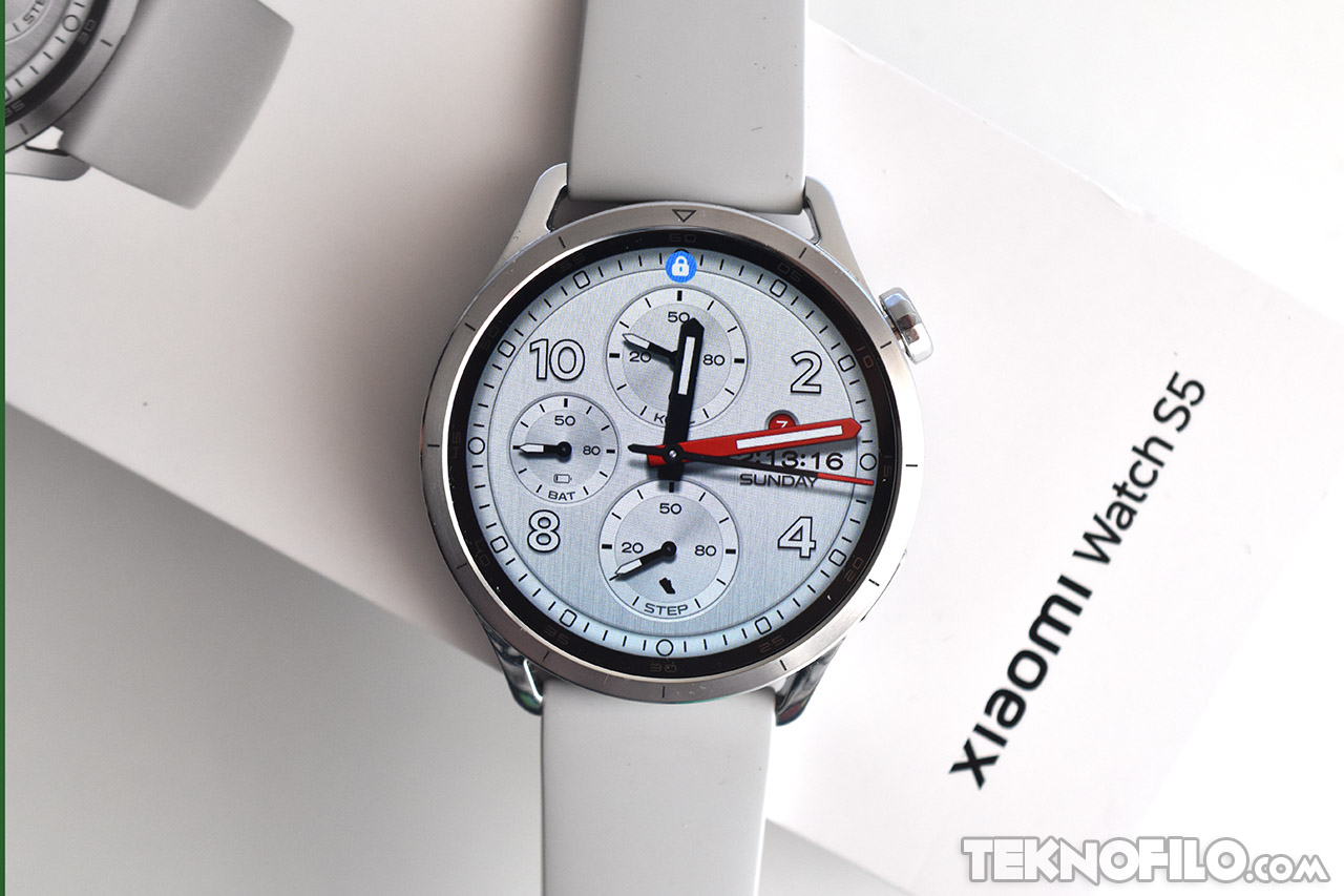 Reloj inteligente Xiaomi Watch S5 con correa gris y carátula analógica sobre caja de presentación blanca.
