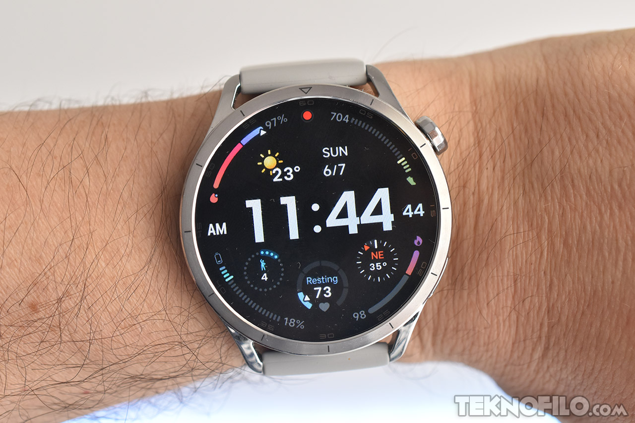 Reloj inteligente en muñeca mostrando hora, clima y datos de salud en pantalla digital en fondo blanco.