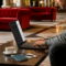 LG gram Pro 2026 llega a España con chasis Aerominum y solo 1.199 gramos Hombre trabajando en laptop en salón de hotel con maleta, café y pasaporte sobre la mesa. Ambiante profesional y acogedor.