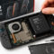 Nintendo prepara una Switch 2 con batería reemplazable en la Unión Europea Consola Nintendo Switch abierta mostrando batería recargable y herramientas de reparación.