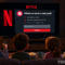 Familia viendo pantalla de Netflix solicitando correo electrónico para perfil, escena de noche acogedora.