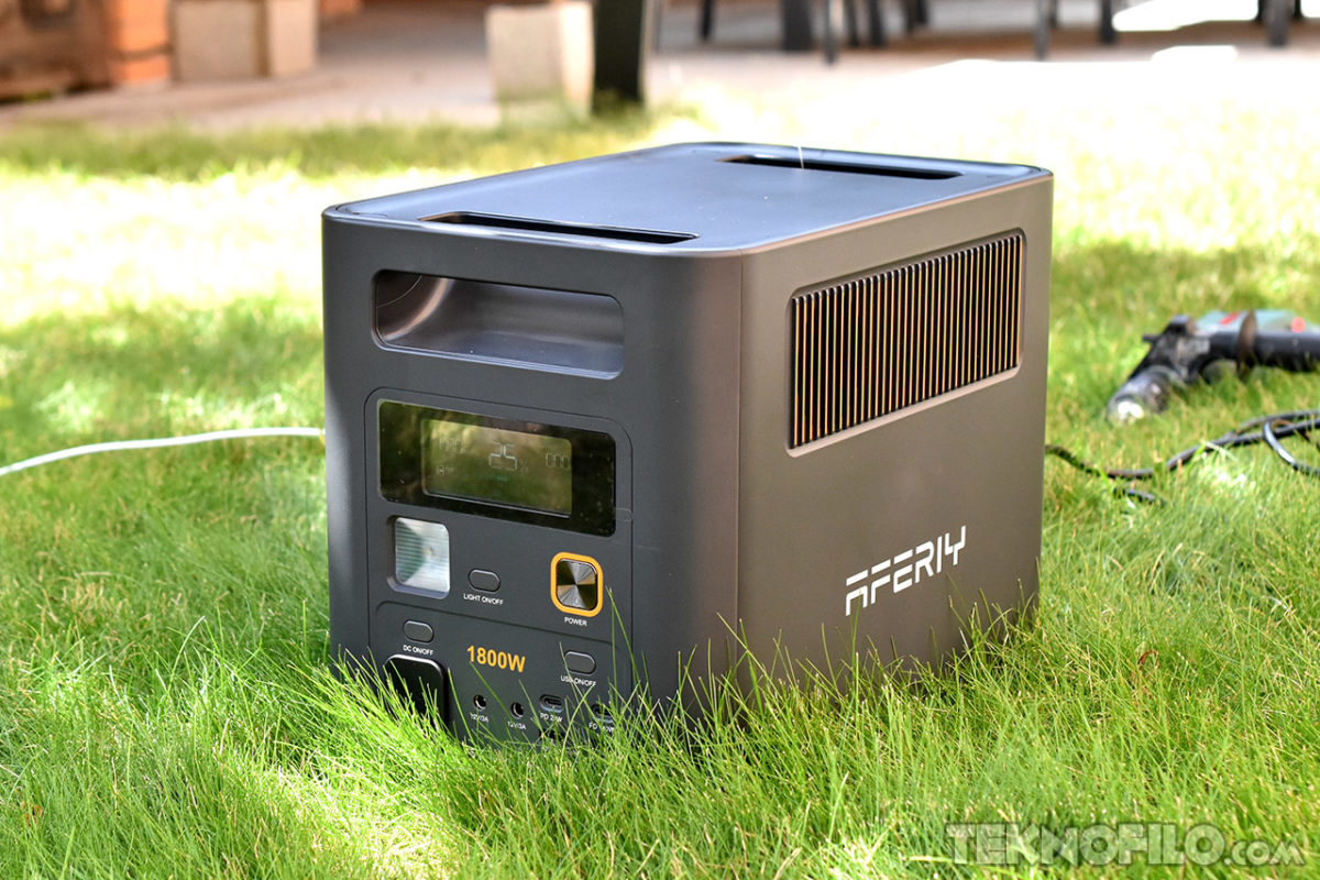 Generador portátil de 1800W para exteriores en césped verde, ideal para camping y actividades al aire libre.