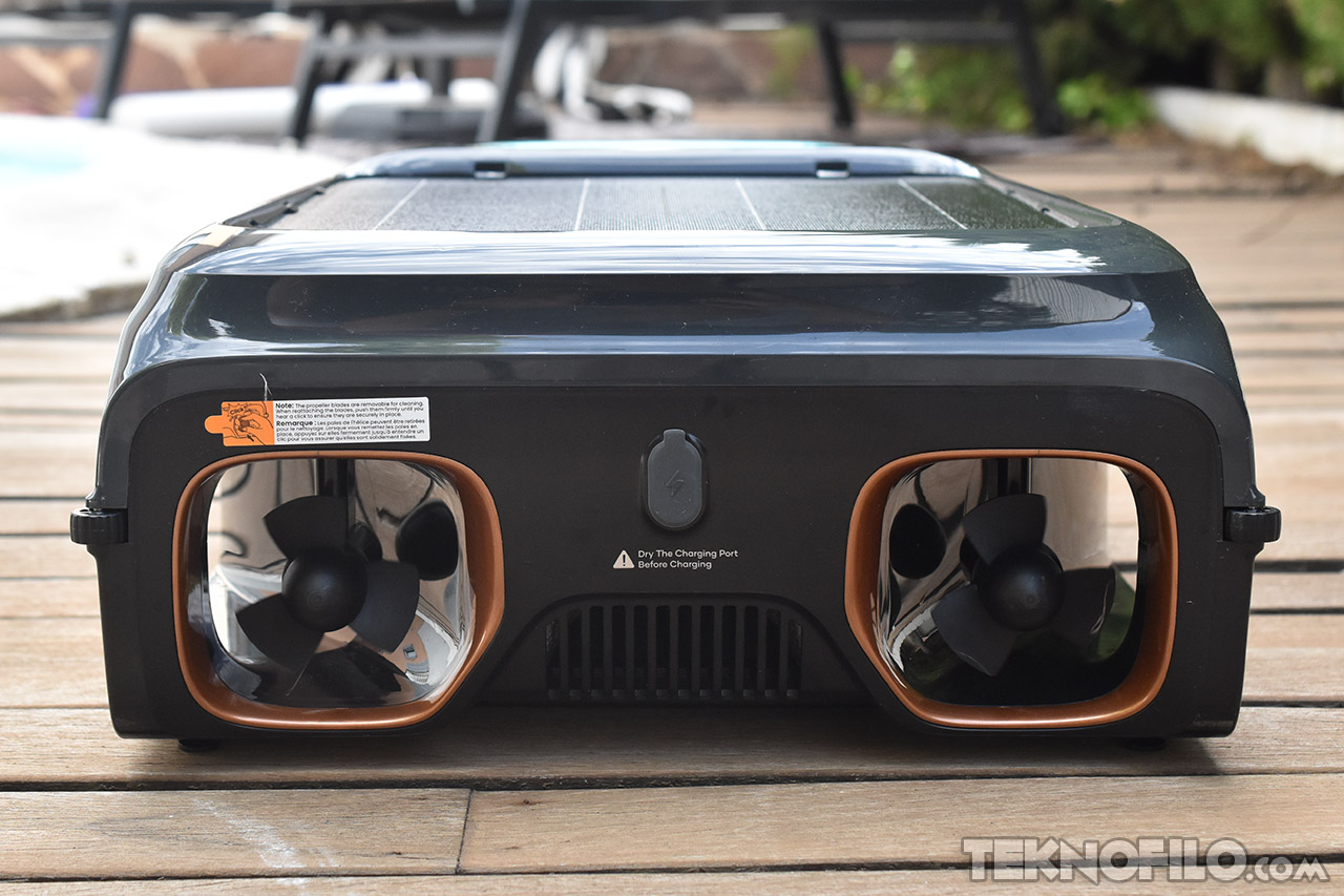 Dispositivo robótico para limpiar piscinas en una terraza de madera. Tecnología avanzada para mantenimiento acuático.
