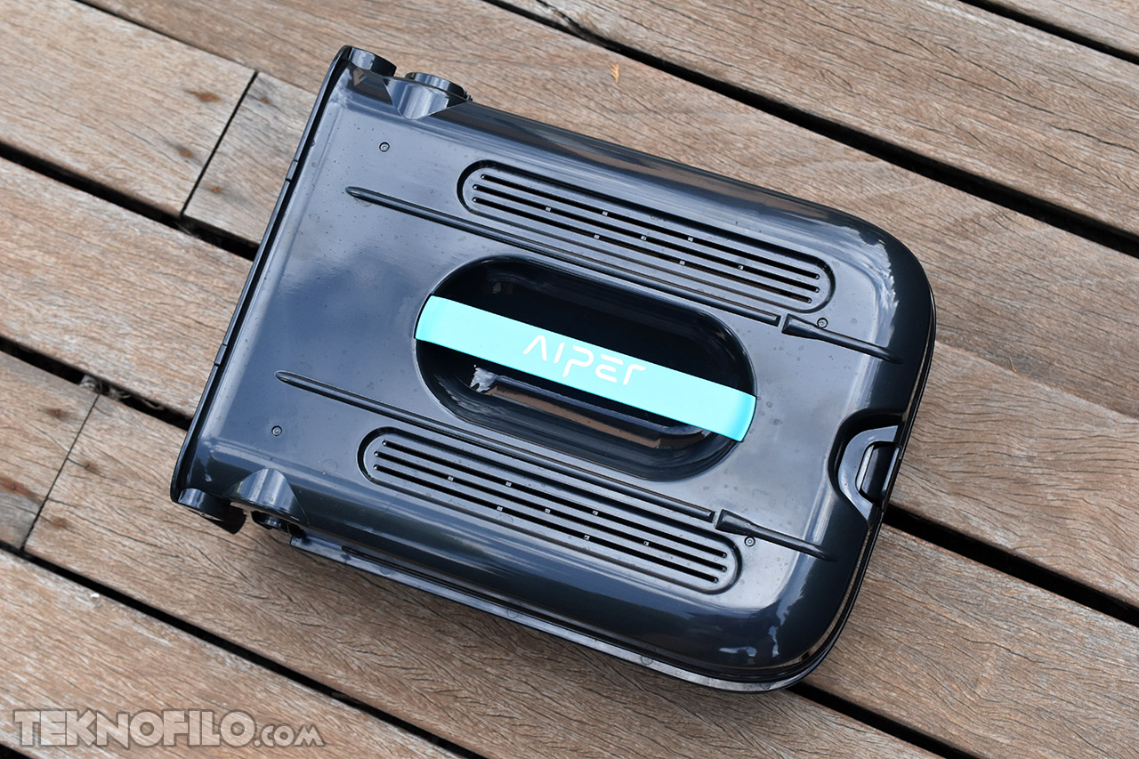 Robot limpiador de piscina Aiper en terraza de madera, diseño compacto y portátil.