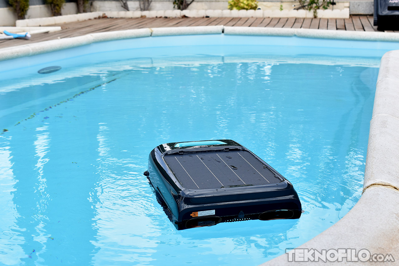 Robot limpiador de piscinas automático en funcionamiento en una piscina azul. Ideal para mantenimiento sin esfuerzo.